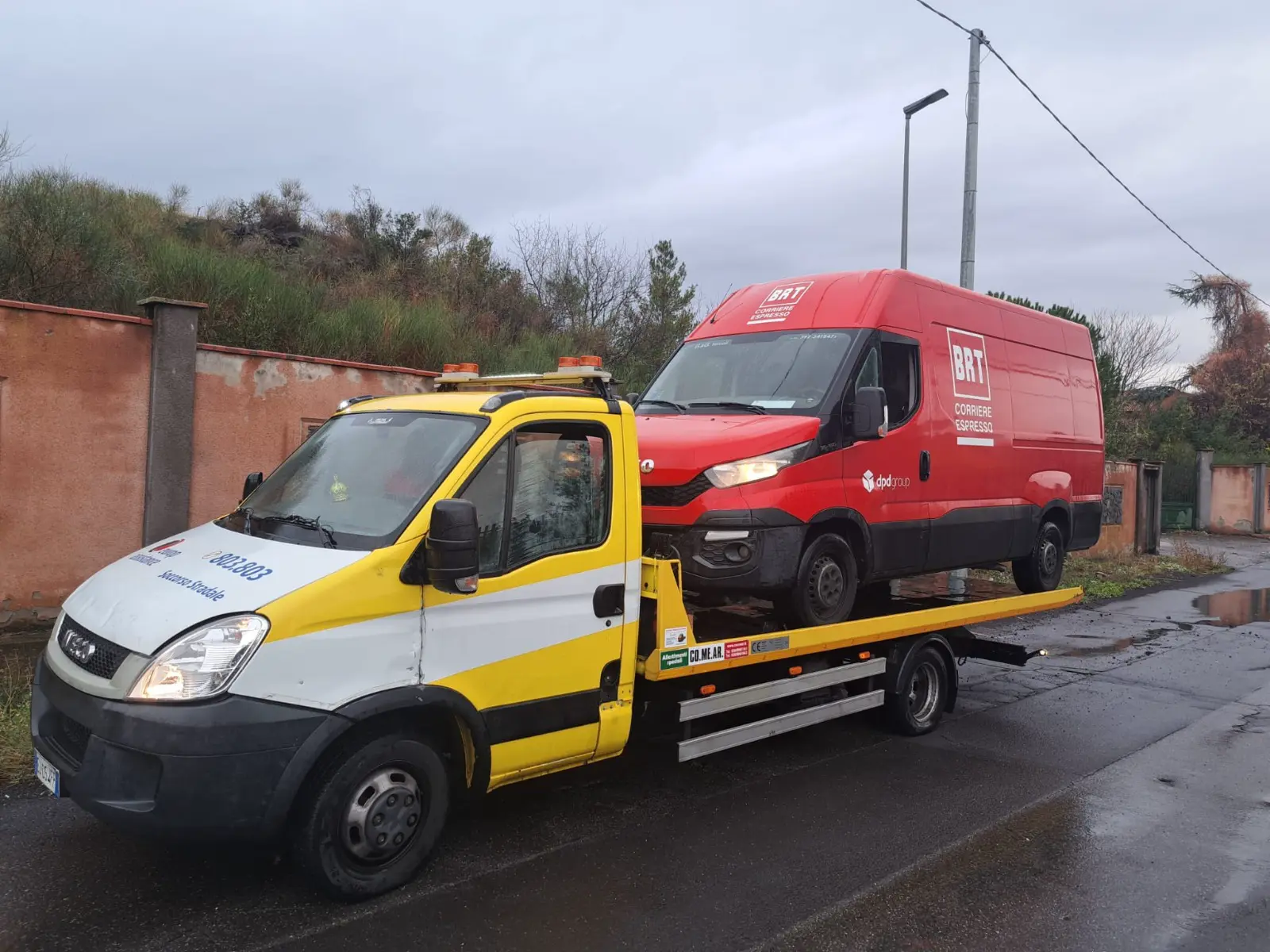 Carroattrezzi giallo e bianco che trasporta un furgone rosso